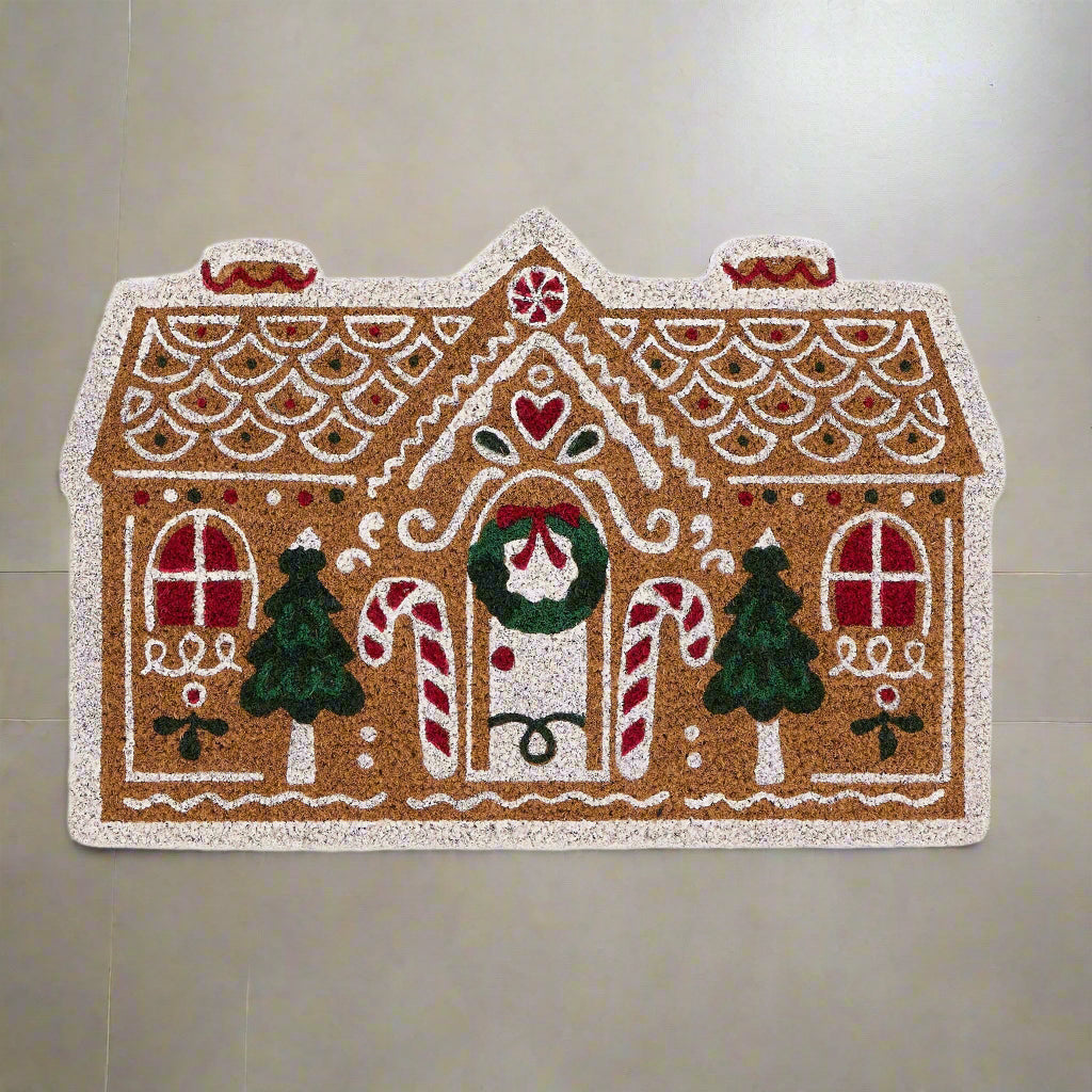 Decorative gingerbread house-shaped mat with candy cane, trees, and heart design on a white background.