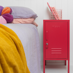 Red locker-style cabinet next to a bed with colorful bedding