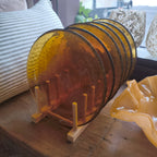 Set of amber glass plates on a wooden stand with a blurred background