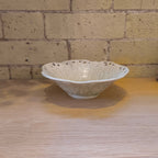 Sakashi ceramic bowl on a wooden table with brick wall behind