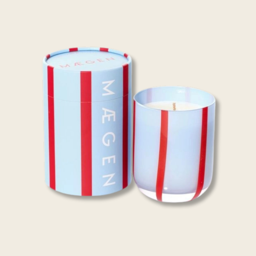 Candle with striped design and 'Magen' branding on a beige background
