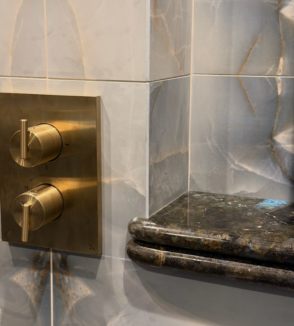 Bathroom tiles and marble close up with shower controls