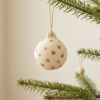Decorative ball with brown spots hanging on a white background