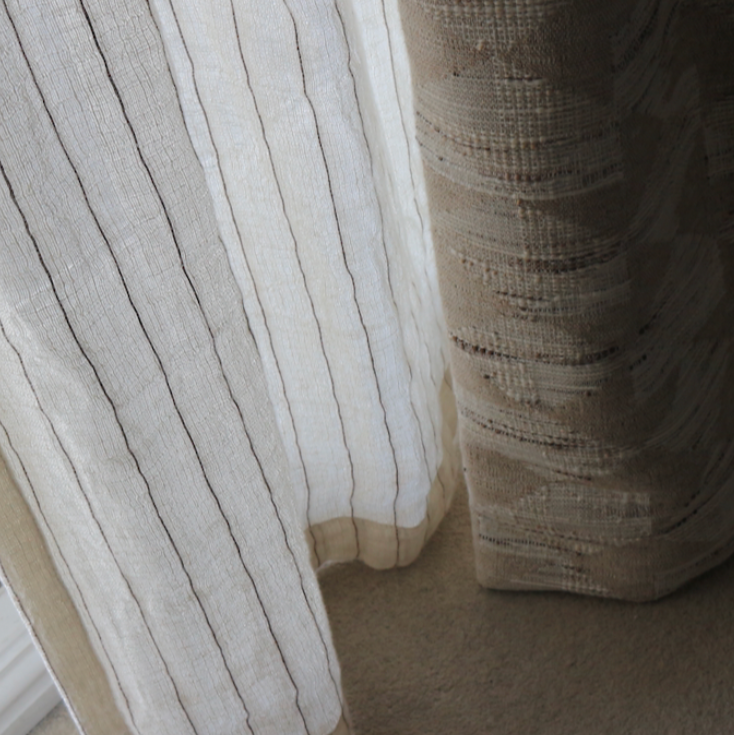 Close-up of textured curtains with a neutral color palette.