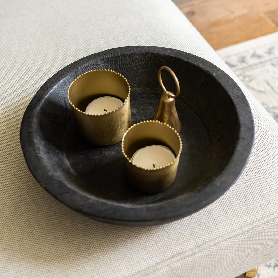 Decorative black bowl with gold accents on a textured surface