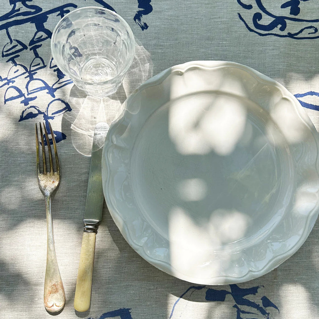 White ceramic plate with a fork on a blue and white patterned tablecloth