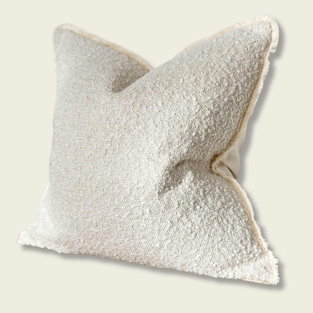large cream natural boucle cushion on a beige background