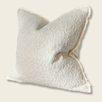 large cream natural boucle cushion on a beige background