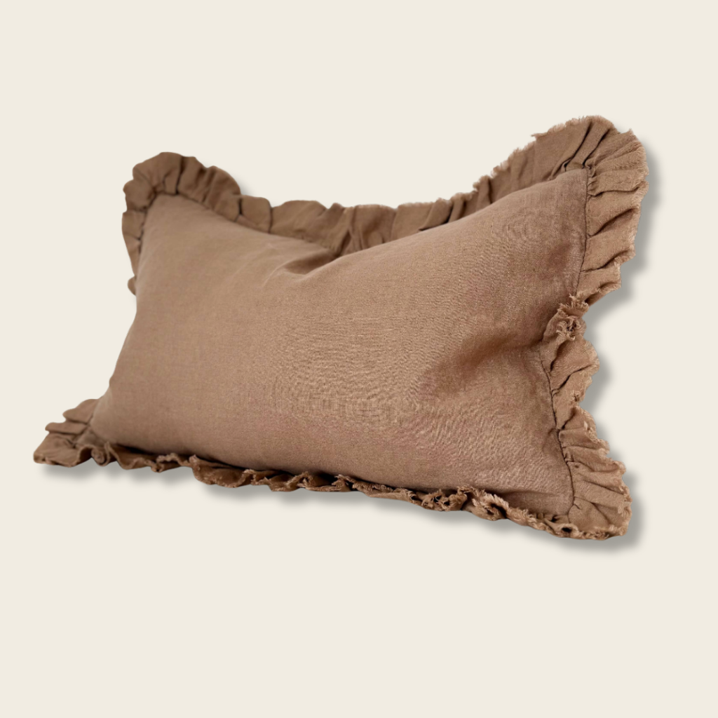 Brown pillow with ruffled edges on a beige 