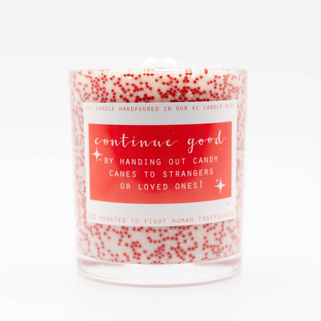 Candle with a red label and red speckles on a white background