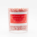 Candle with a red label and red speckles on a white background