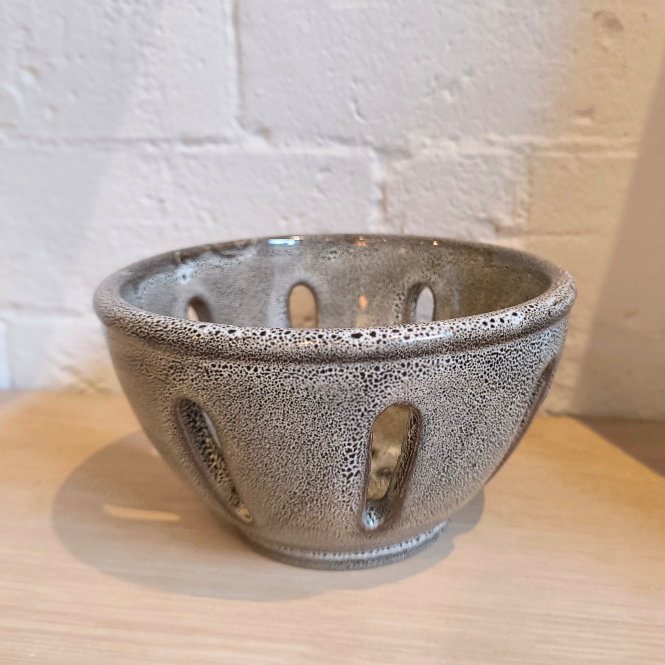 Ceramic bowl with textured surface on a wooden surface