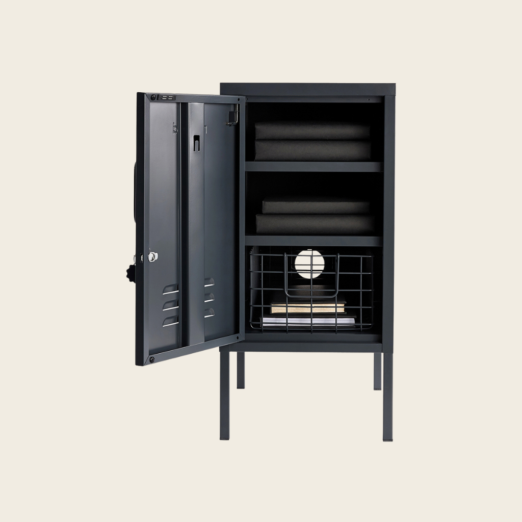 Black metal locker with open door on a beige background