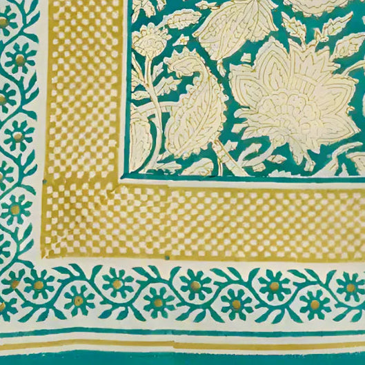 Folded fabric with green and beige patterns on a beige background