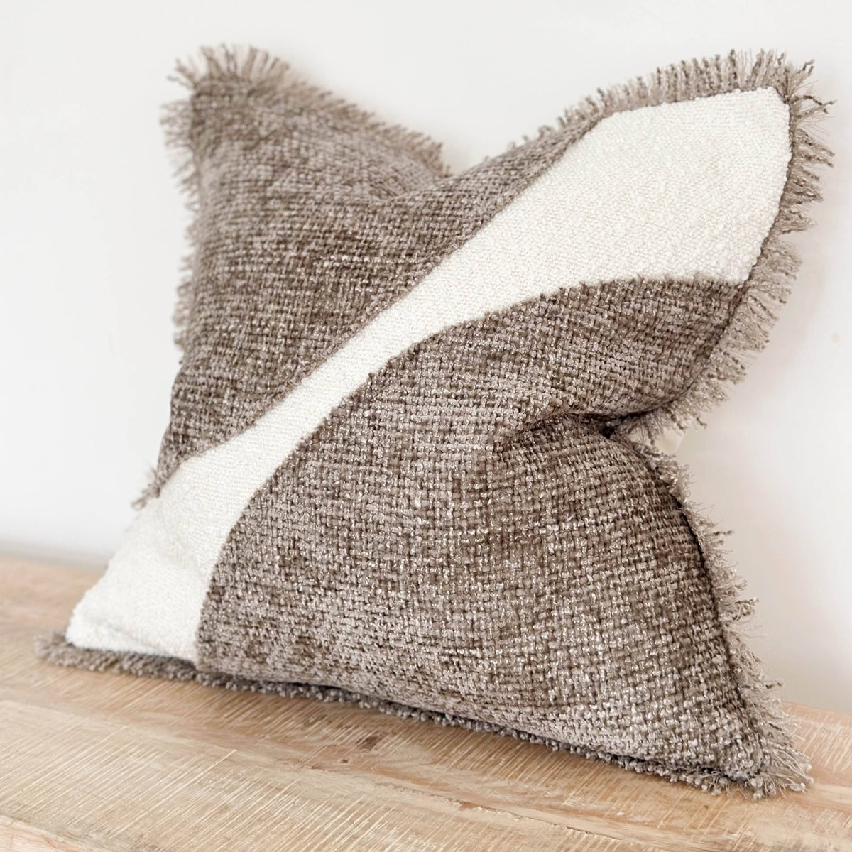 Textured pillow with a white center on a wooden surface