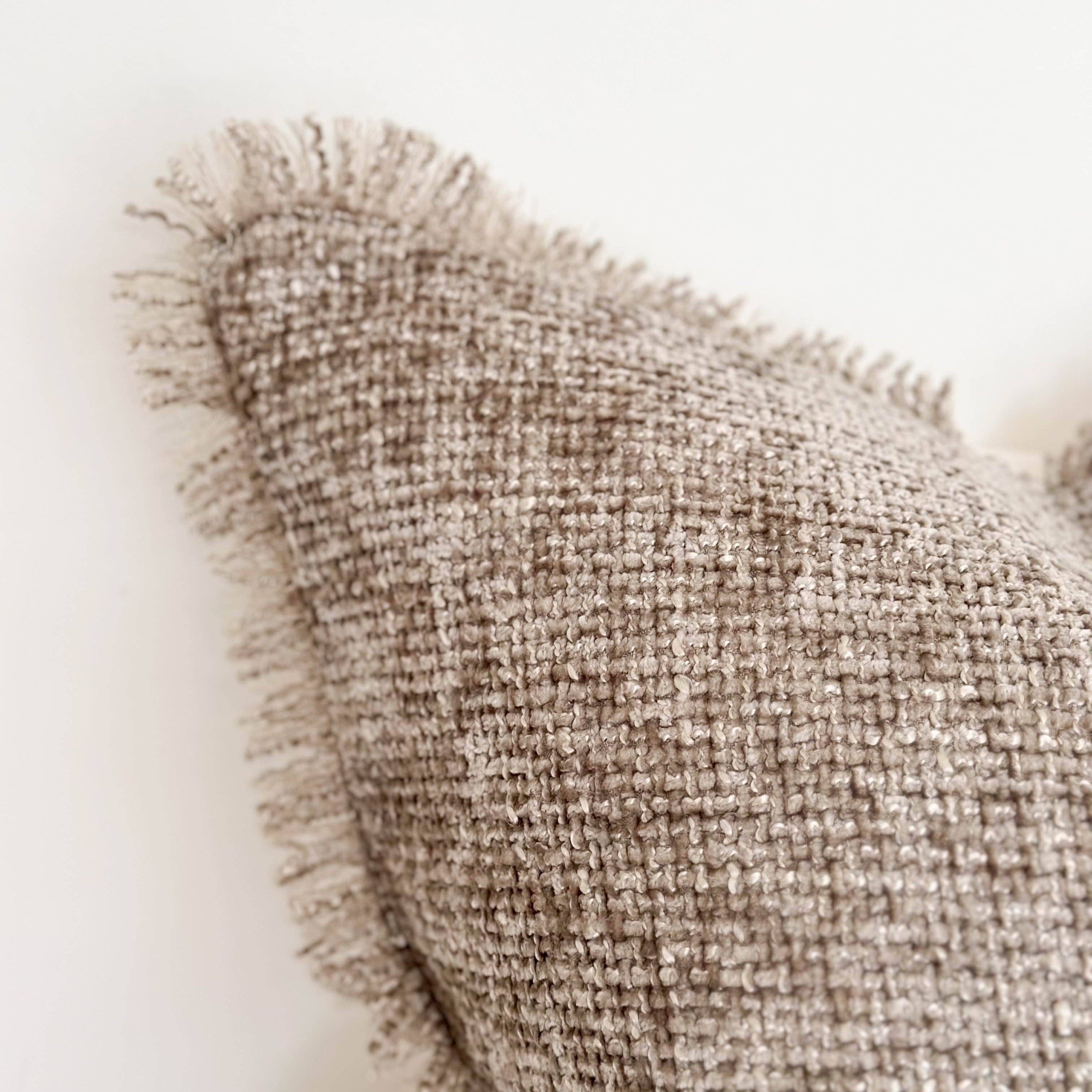 Textured beige pillow on a white background