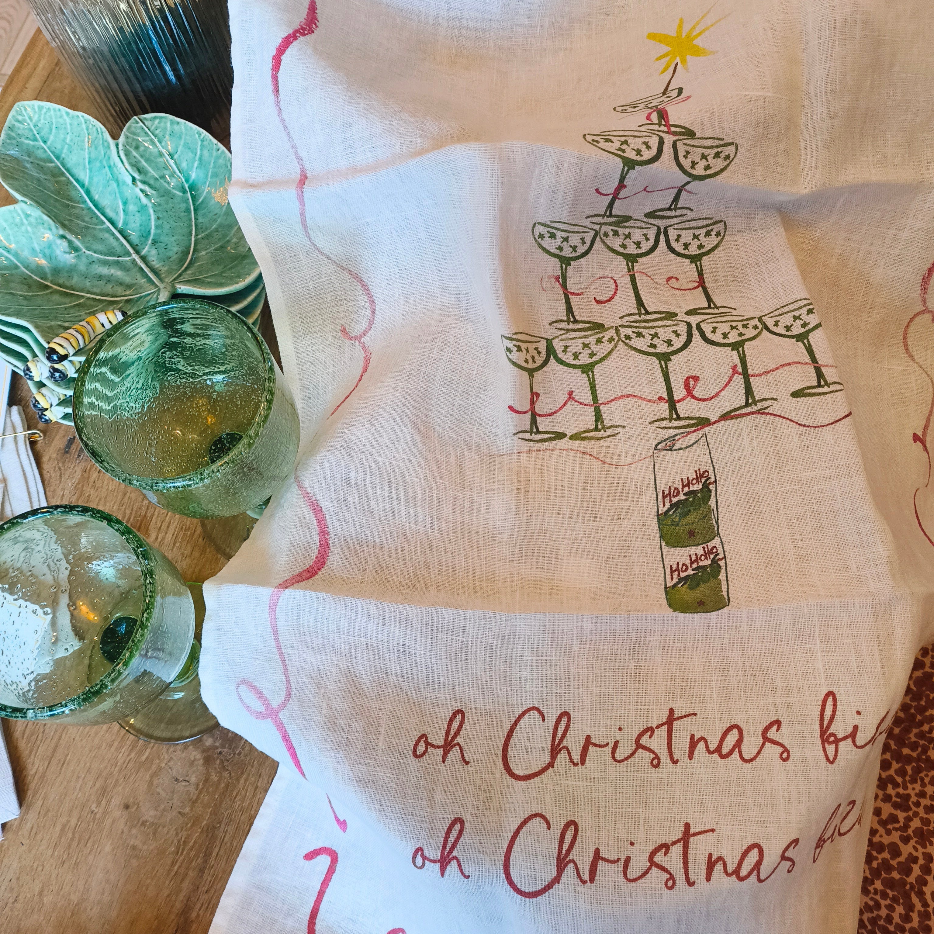 Decorative towel with Christmas design and text on a table setting.