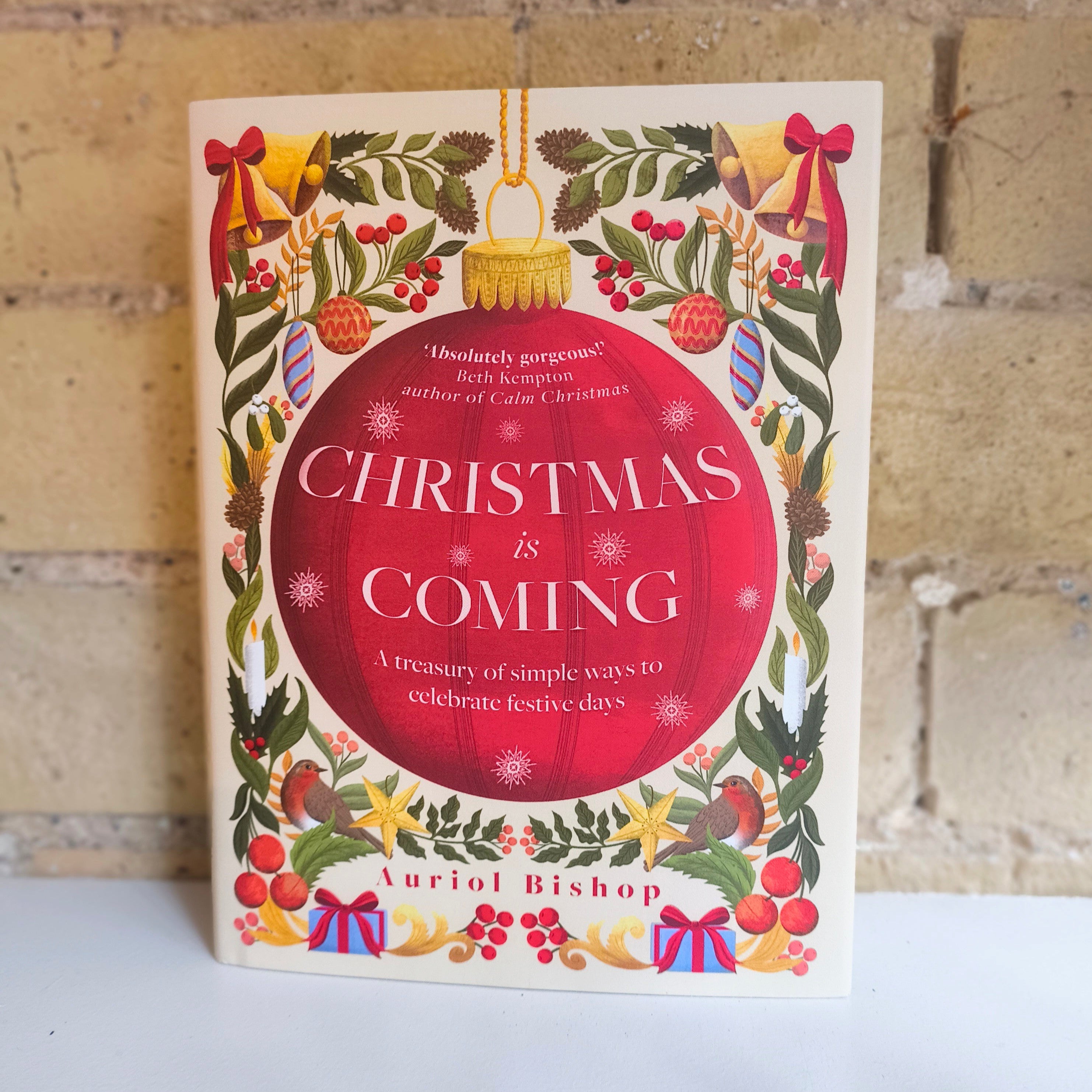 Book titled 'Christmas is Coming' by Auriol Bishop with festive cover design on a white surface.