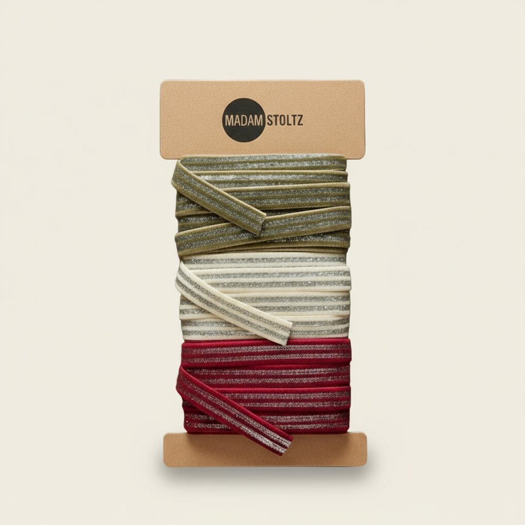 Packaged hair elastics with a 'Madam Stoltz' label on a white background