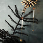 Decorative Christmas tree with gold star-shaped ornament and candles against a dark background