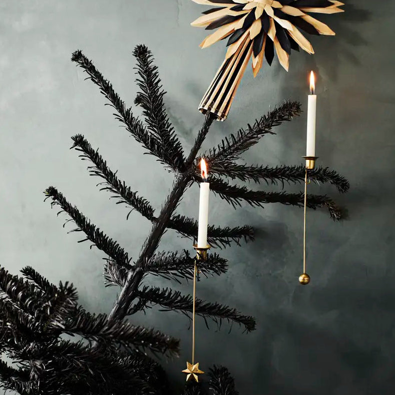 Decorative Christmas tree with gold star-shaped ornament and candles against a dark background
