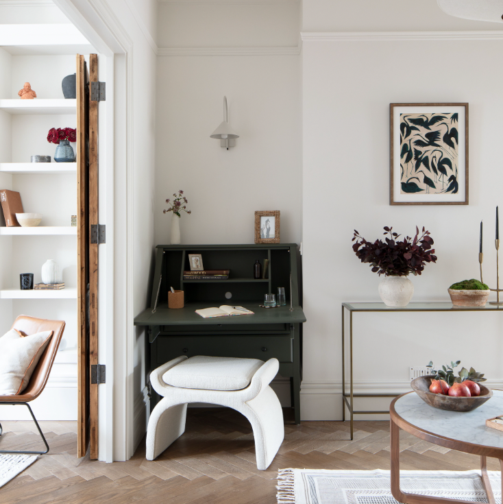 Modern home office with a desk, chair, and decorative elements.