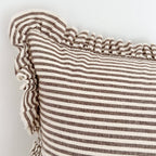 Close-up of a striped pillow with ruffled edge on a light background