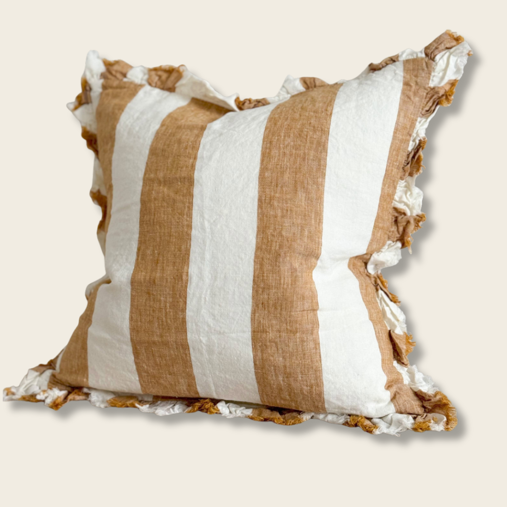 Striped pillow with brown and white stripes on a beige background