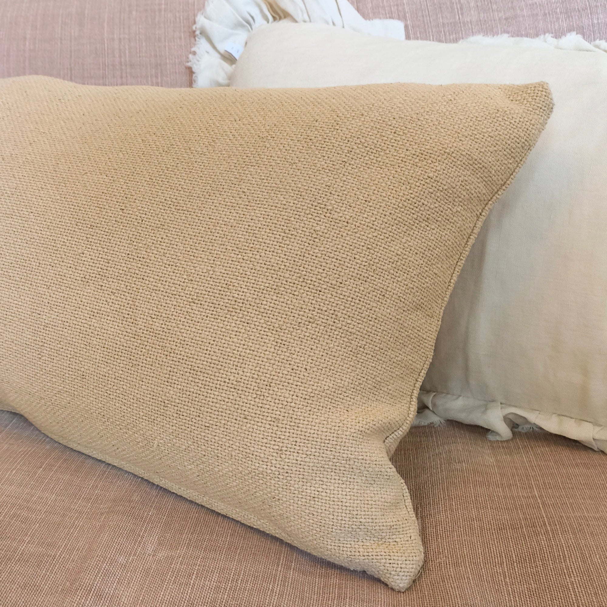 Beige pillow on a beige sofa with a blurred background
