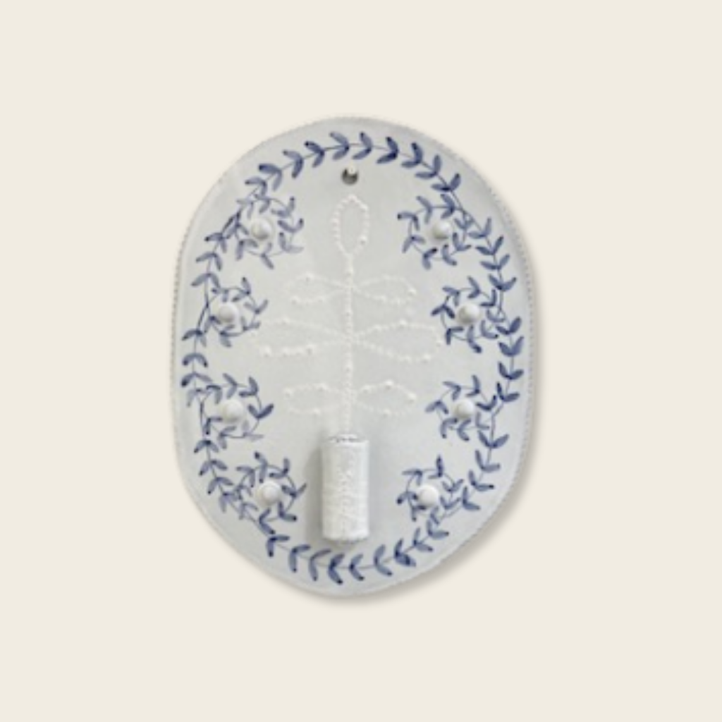 Decorative wall hook with blue floral pattern on a light beige background