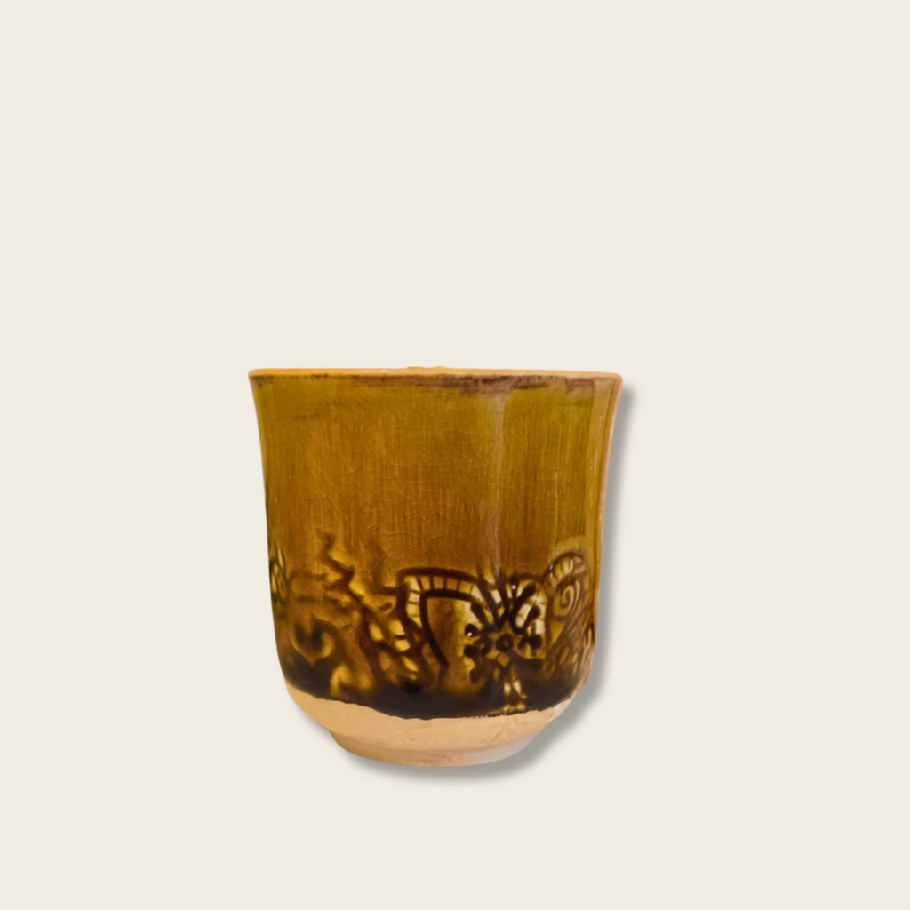 Ceramic cup with decorative patterns on a white surface