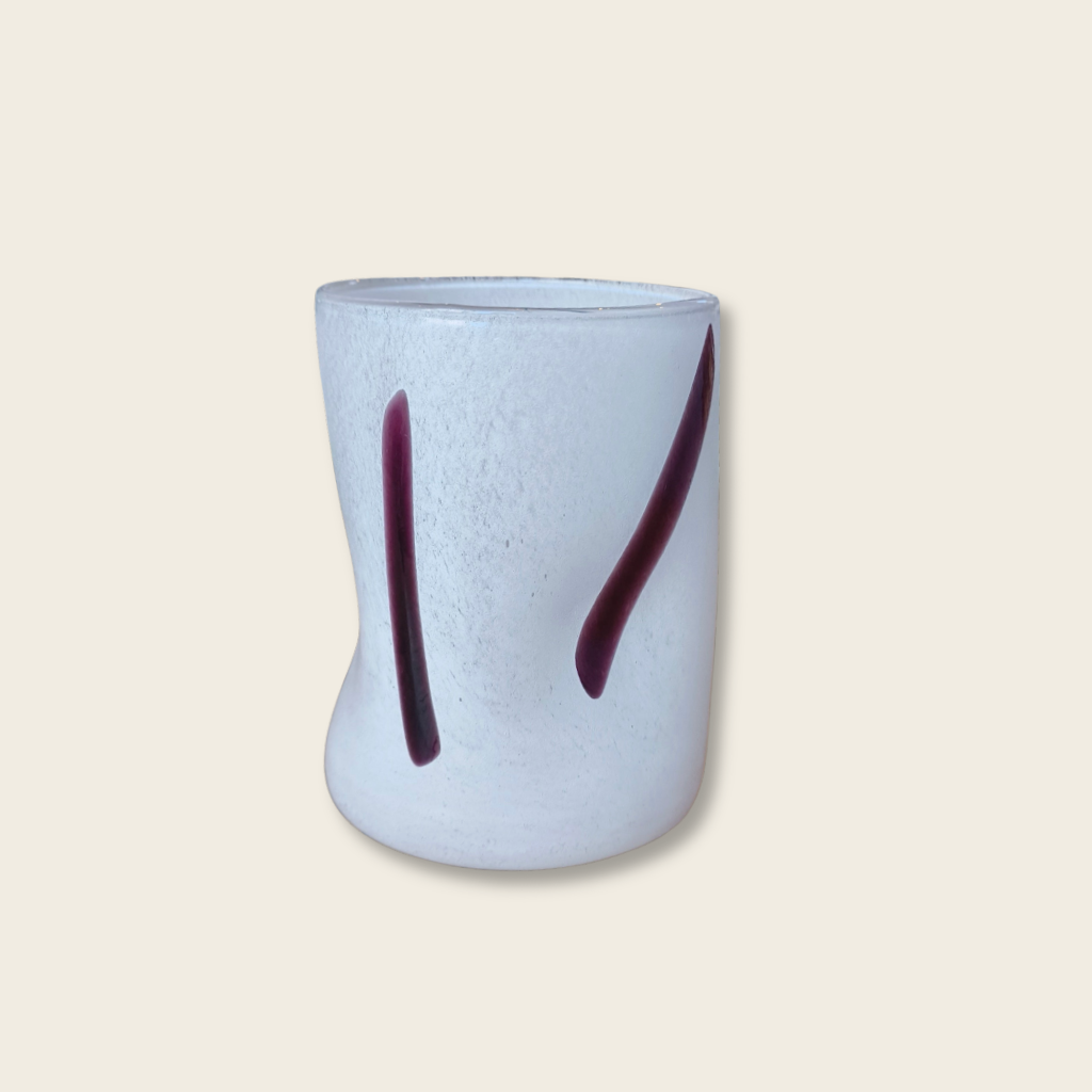 white glass tubler with speckled surface and two black brush stroke details