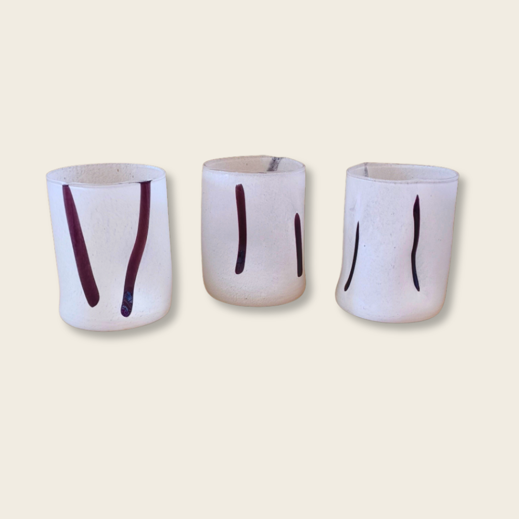 three white speckled glass tumblers with differing black brush stroke marks
