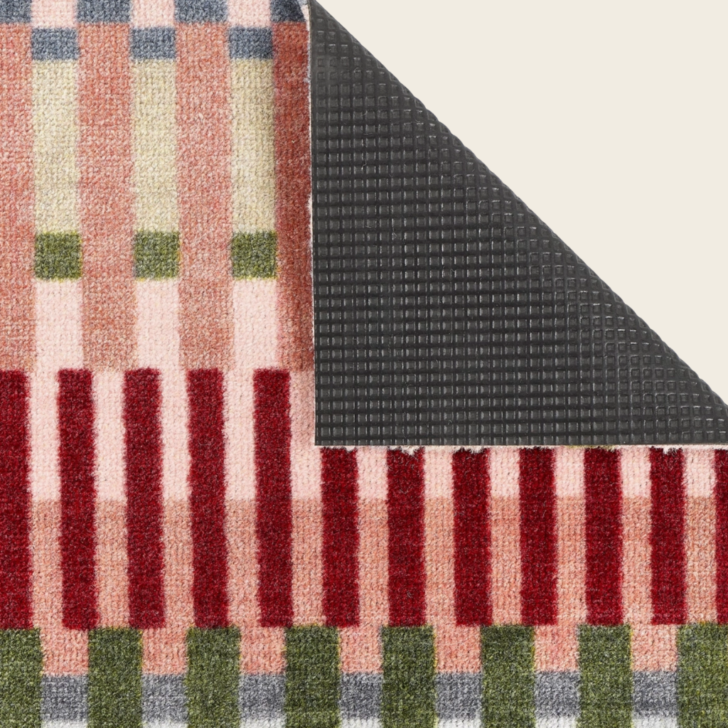 Textile with plaid pattern featuring red, green, and beige colors on a textured black background.