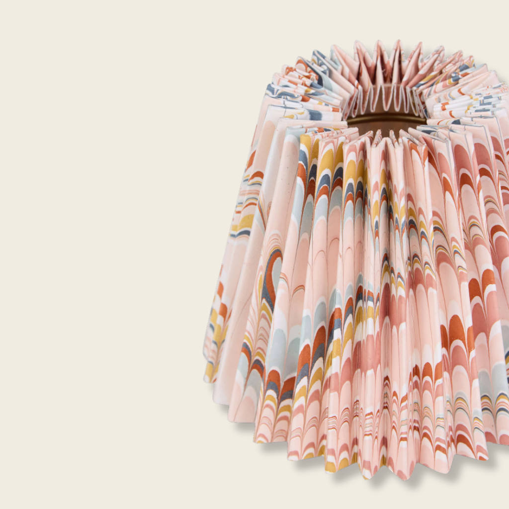 detail of a pink marbled pleated lampshade on a beige background