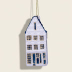 Decorative house ornament with blue and gold details on a white background