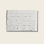 Handmade cotton rag paper card with i love you repeated on a beige background