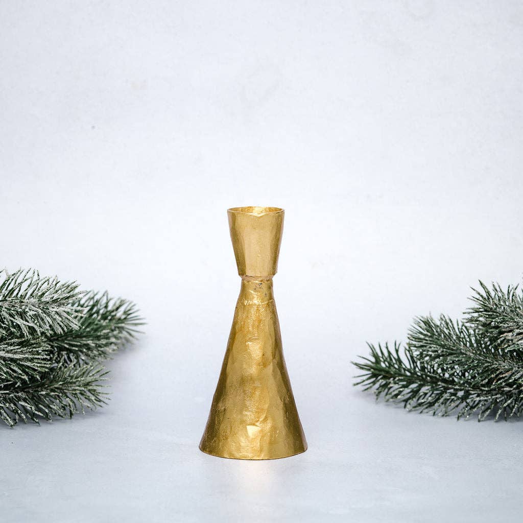 Gold decorative bell with Christmas tree branches on a light gray background