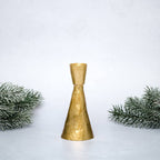 Gold decorative bell with Christmas tree branches on a light gray background