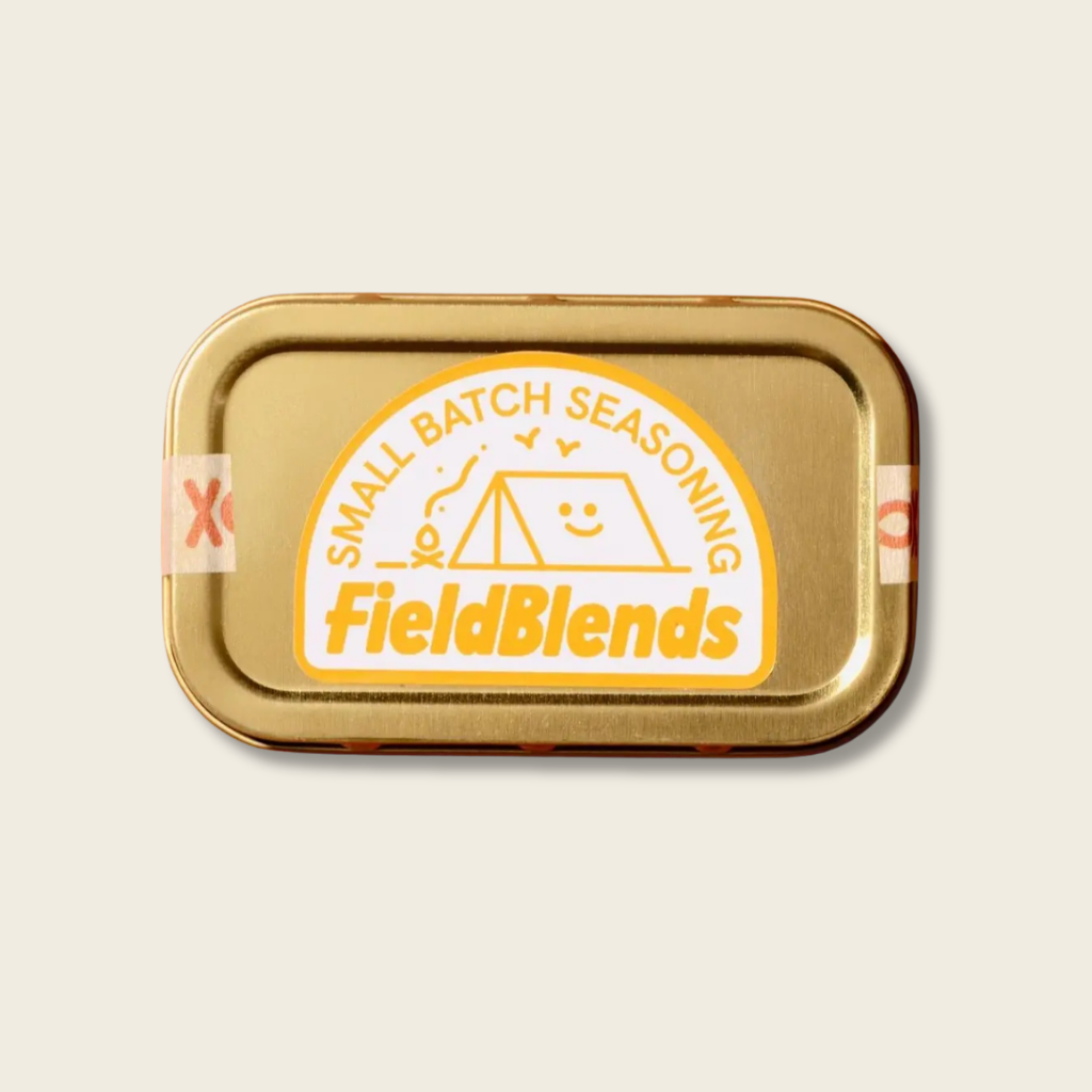 Gold seasoning tin with 'FieldBlends' branding on a beige background