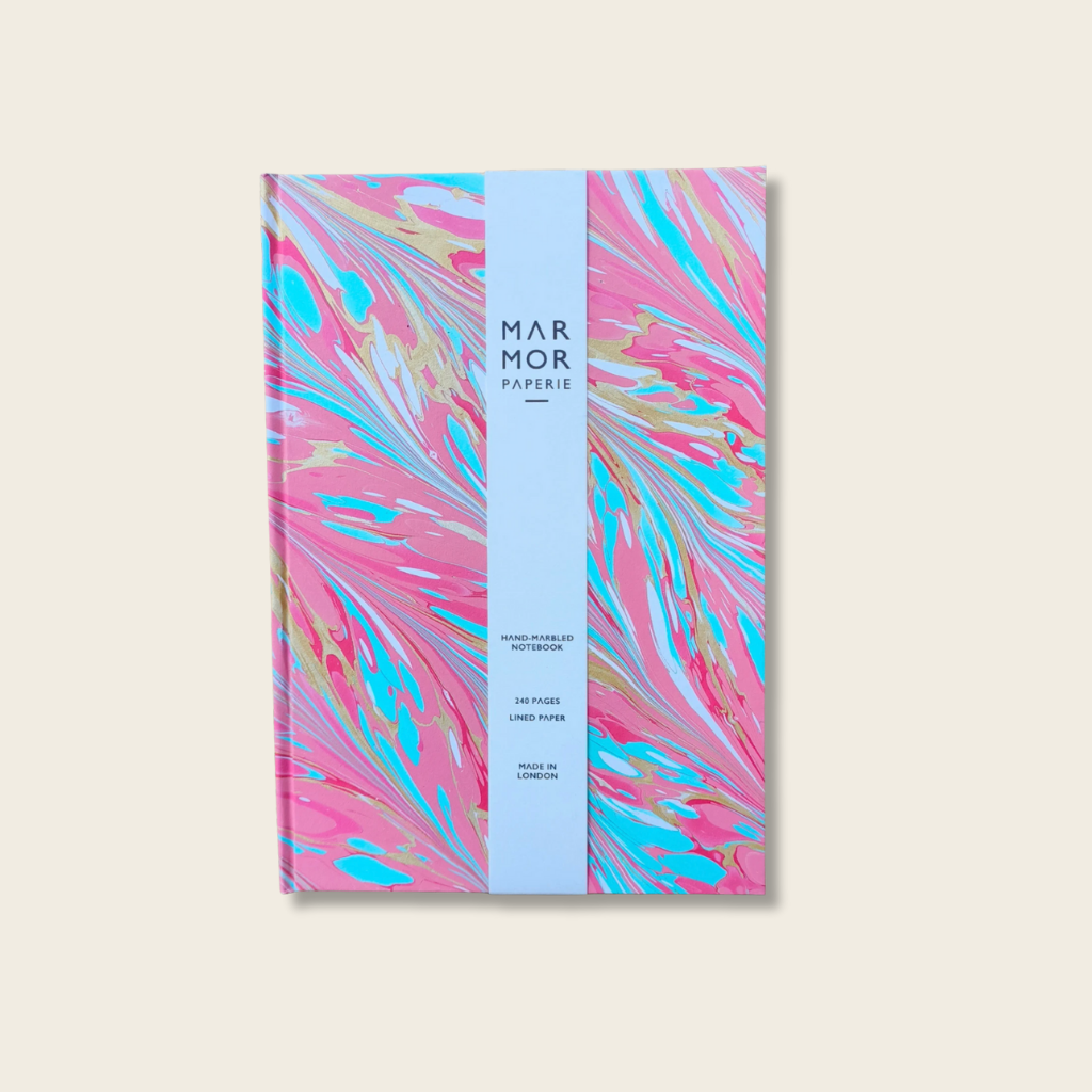 Notebook with colorful marbled design on a light beige background