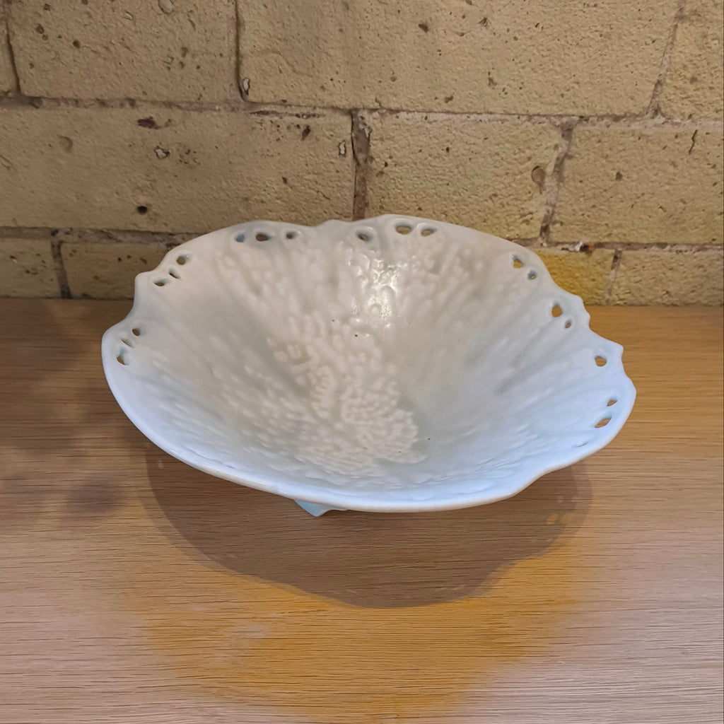 White ceramic bowl with textured surface on a wooden surface
