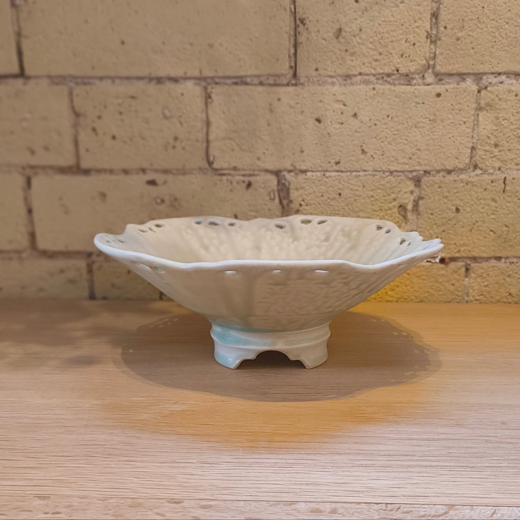 White ceramic bowl on a wooden surface with a brick wall background