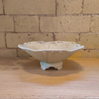 White ceramic bowl on a wooden surface with a brick wall background