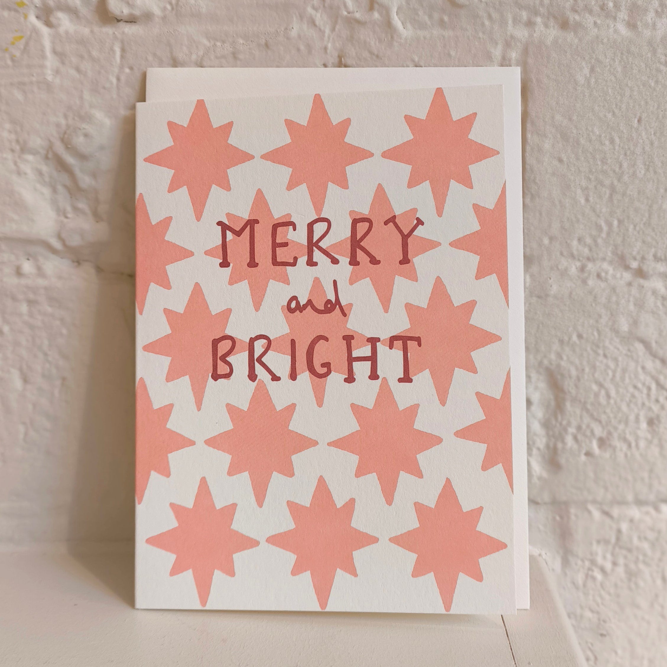 white card with pink stars and writing merry and bright