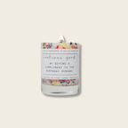 Candle with colorful label and sprinkles on a white background