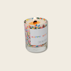 Candle with colorful sprinkles and a 'Happy Birthday' label on a light background