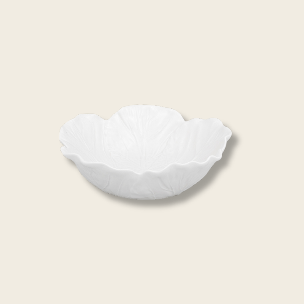 small cream cabbage leaf shaped bowl on a beige background