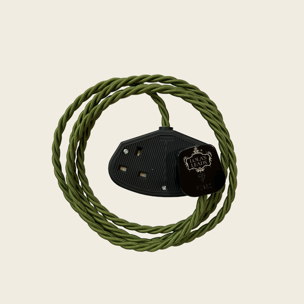 Black leather boot jack with green rope on a beige background