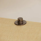 Bronze-colored metal cap on a textured beige surface with a neutral background